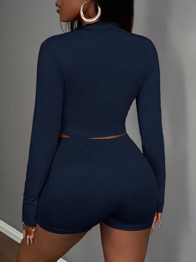 navy half-zip jacket sleeveless crop top and sports shorts