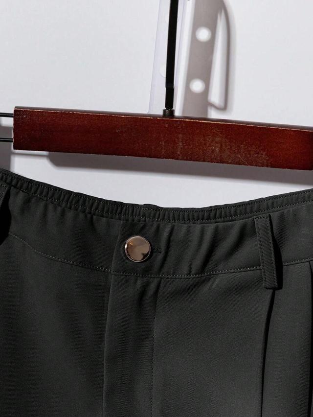 dark green short sleeve button-up shirt and pleated trousers