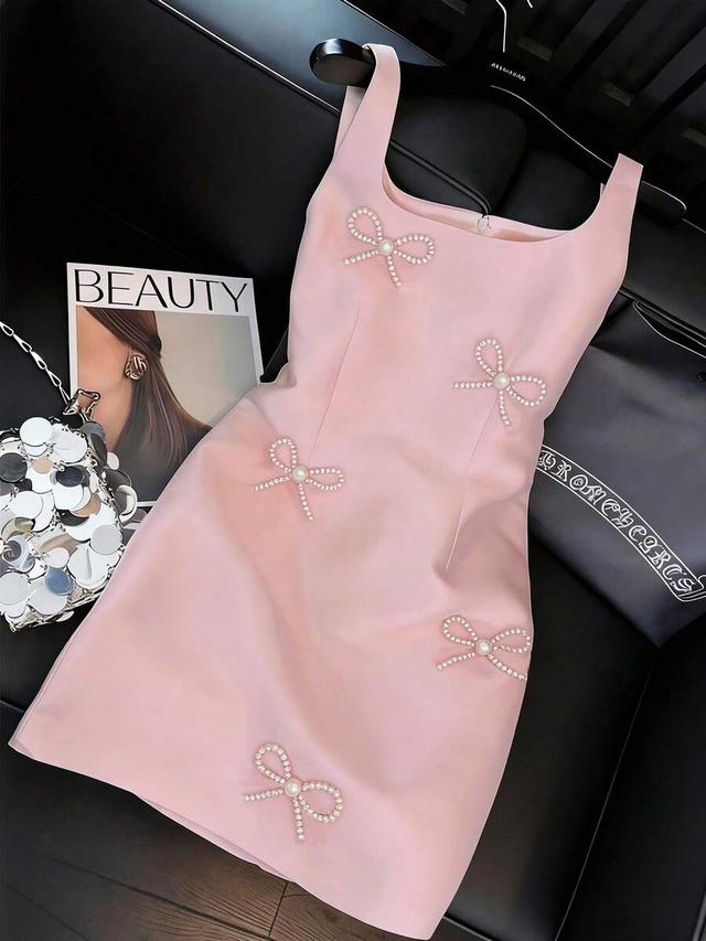 light pink sleeveless mini dress with pearl bow embellishments