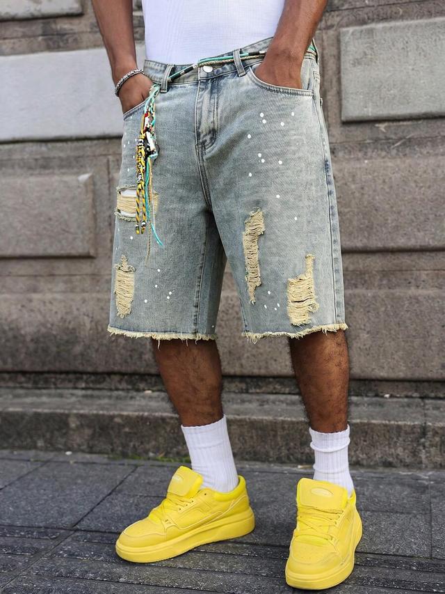 distressed light wash denim shorts with paint splatter