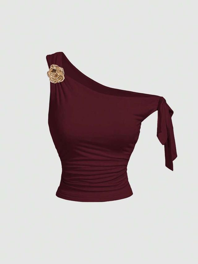 asymmetric neck burgundy top with metal floral decor