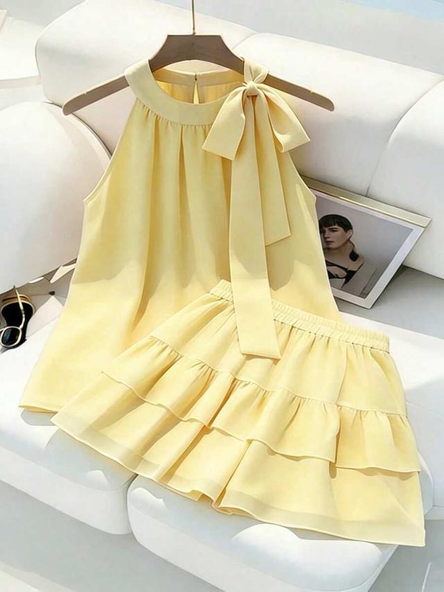 yellow sleeveless tie-front top and ruffled layered skirt