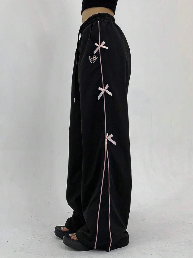 black wide leg trousers with pink bowknot side detailing