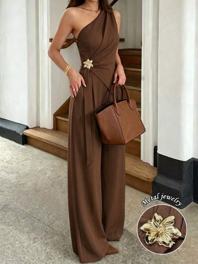 brown one-shoulder jumpsuit with metal flower detail