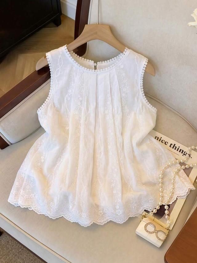 white sleeveless blouse with ruffle neck and embroidery
