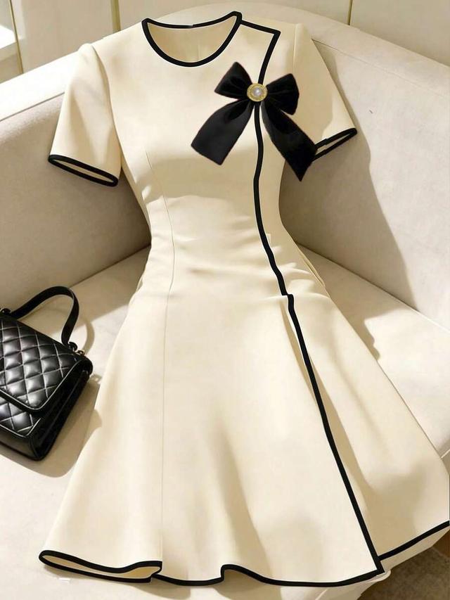 cream a-line dress with black contrast piping and bow