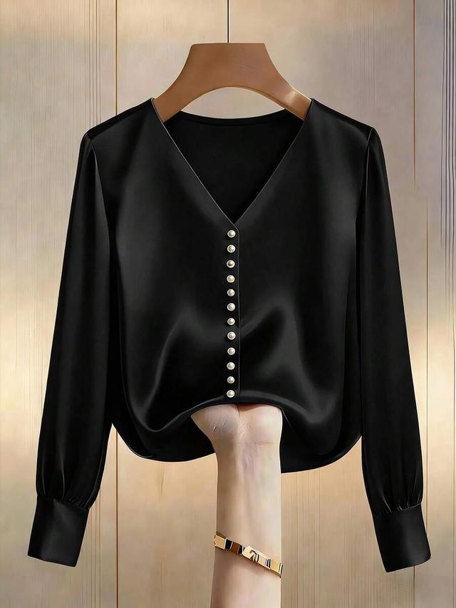 elegant black v-neck blouse with pearl button detailing