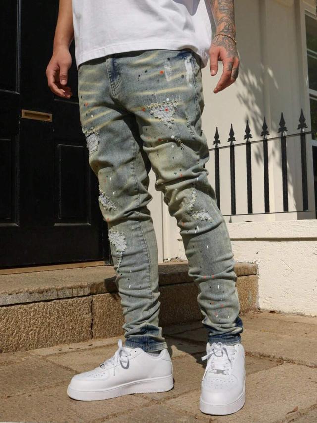 distressed denim jeans with paint splatter detail