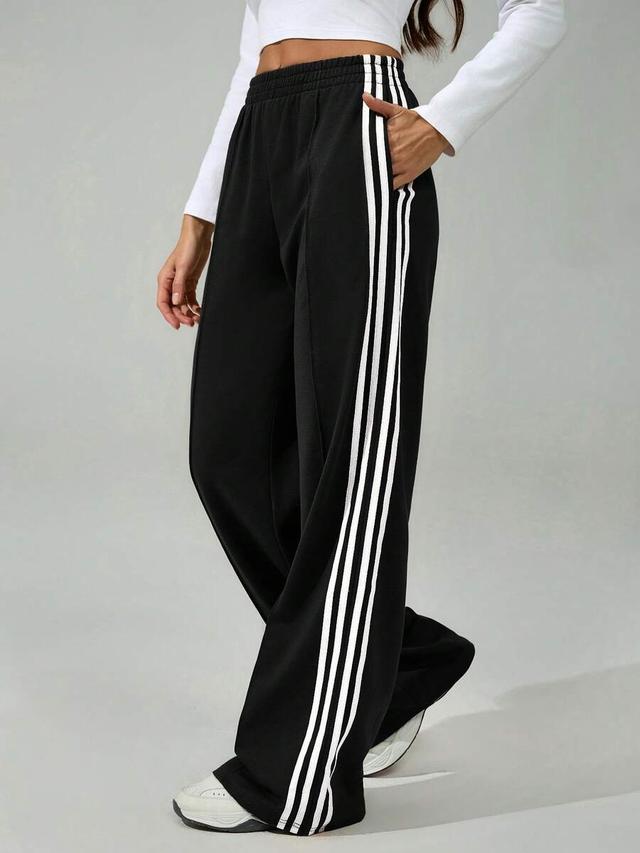 black wide leg sweatpants with white side stripes