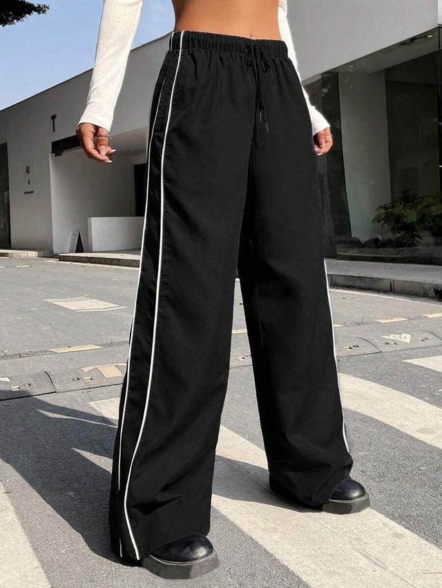 black wide leg trousers with white contrast piping