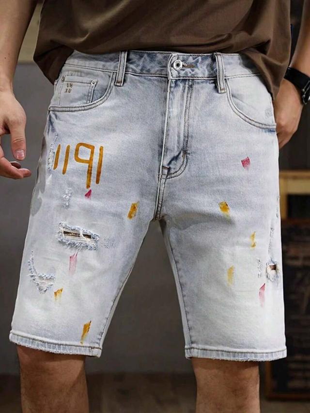 light wash distressed denim shorts with paint splatter