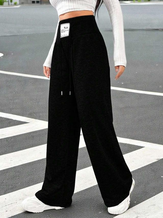 black high-waisted knit sweatpants with letter patch