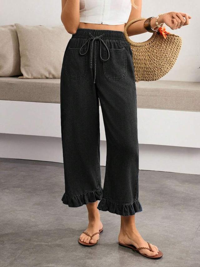 washed black denim jeans with ruffled hem