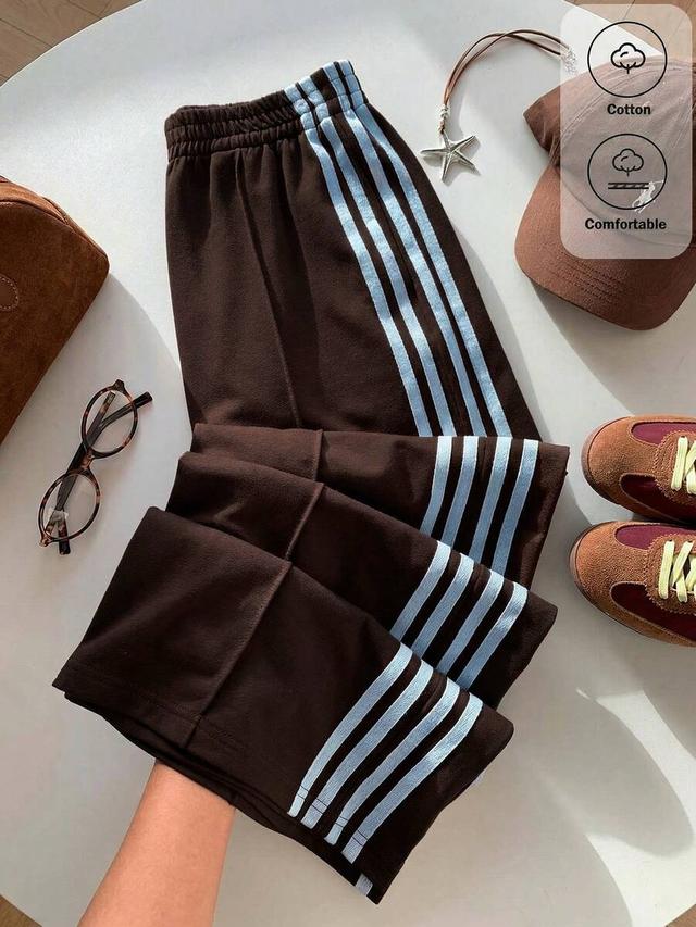 brown wide leg sweatpants with light blue side stripes
