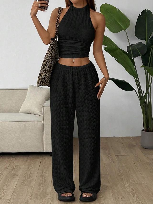 black textured knit sleeveless backless top and trousers