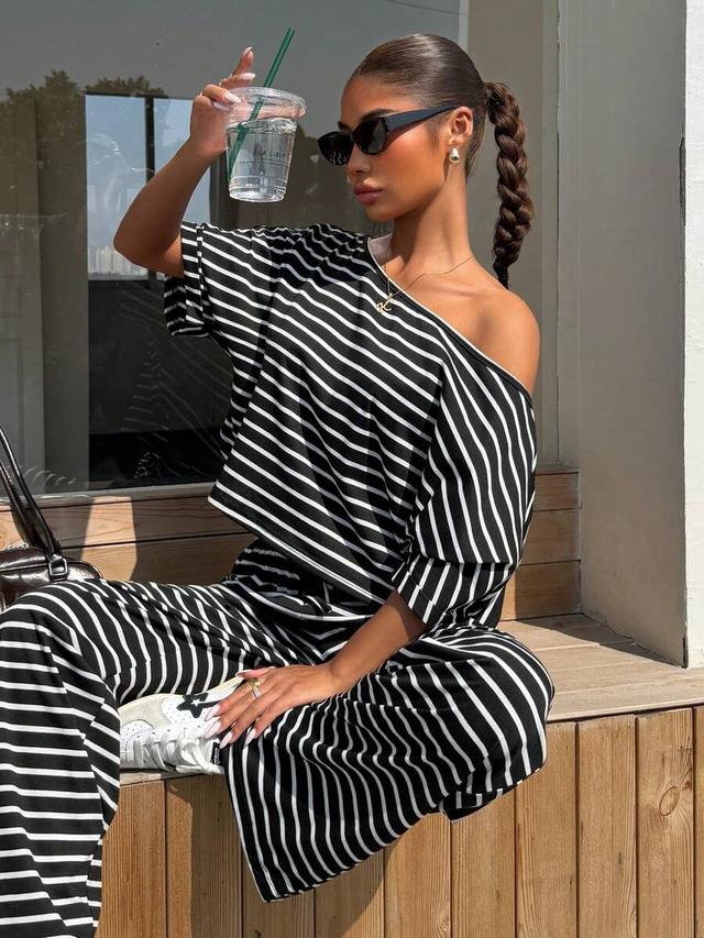 black and white striped asymmetrical shoulder top and trousers