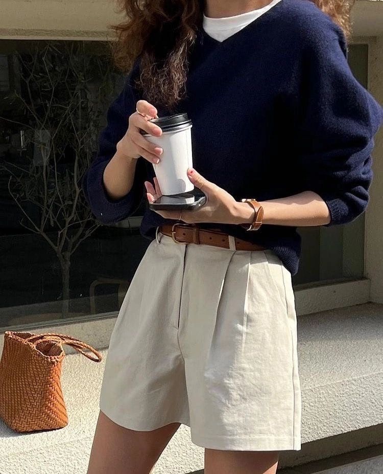 navy v-neck knit sweater over white tee and beige pleated shorts