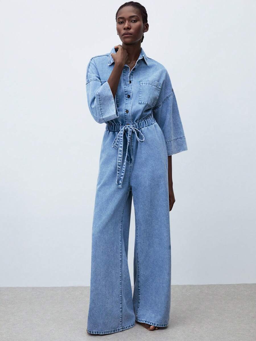 light wash denim jumpsuit with elastic waist and tie