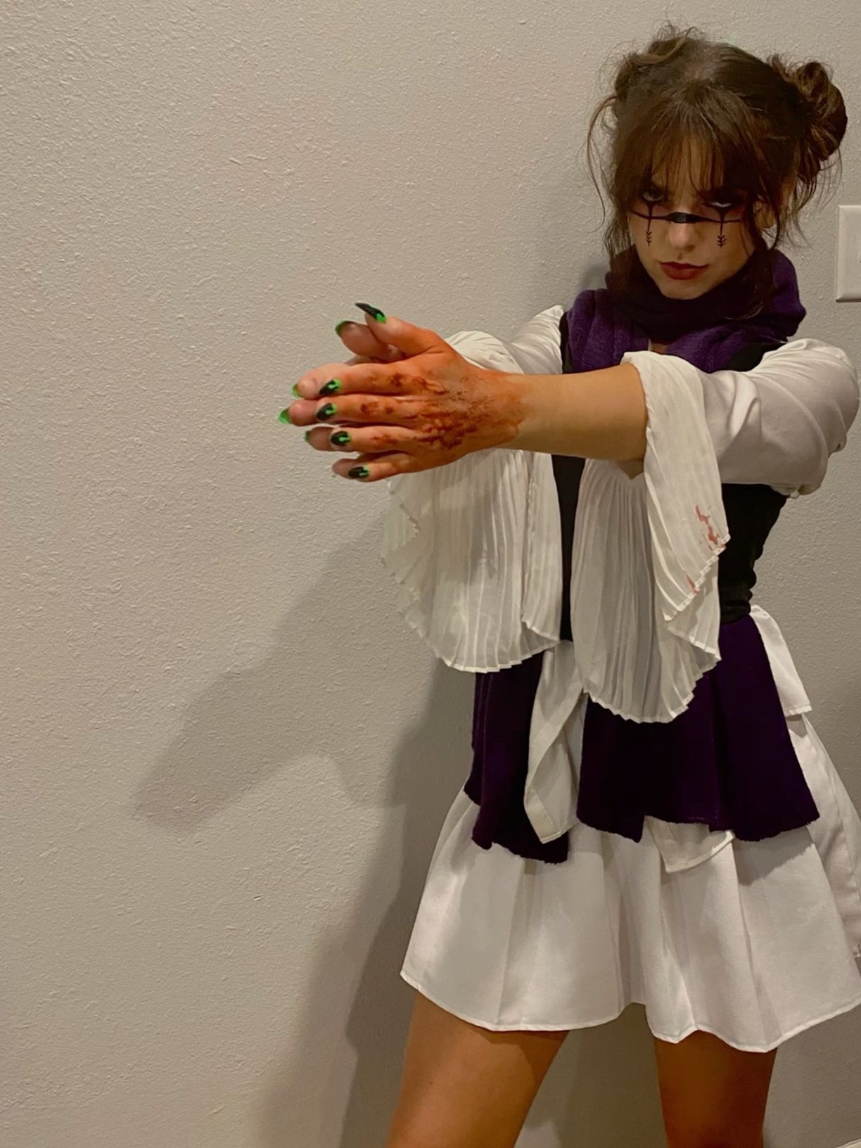 white pleated blouse layered under purple knit vest